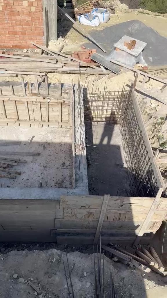 Pool construction area with concrete walls and timber formwork