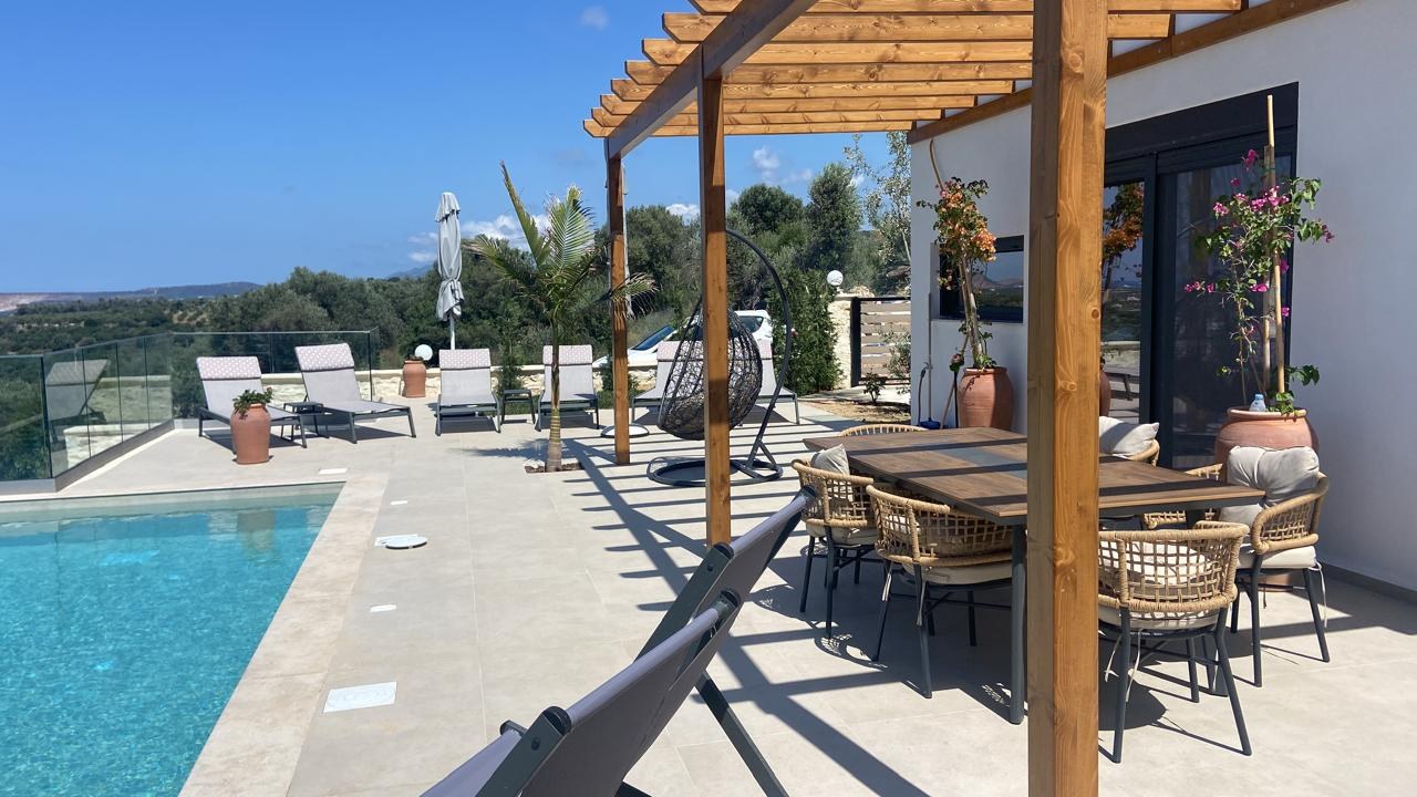 Finished villa terrace with a swimming pool and shaded dining area